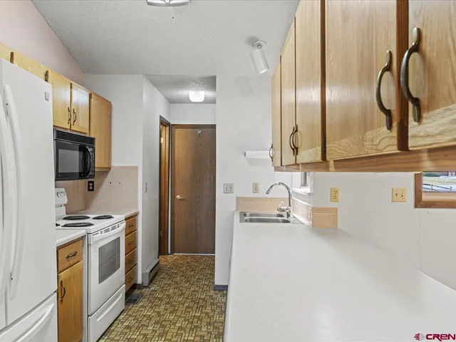 a kitchen with a sink stove and refrigerator