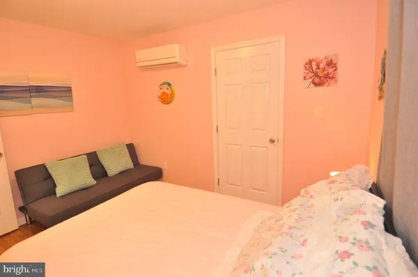 a bedroom with a bed table chair and a window