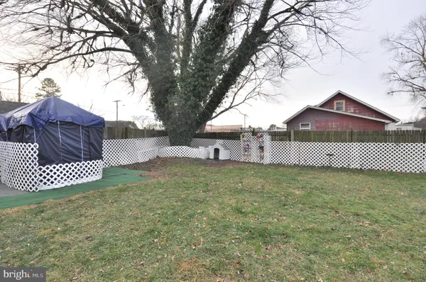 a view of a house with a back yard and wooden fence