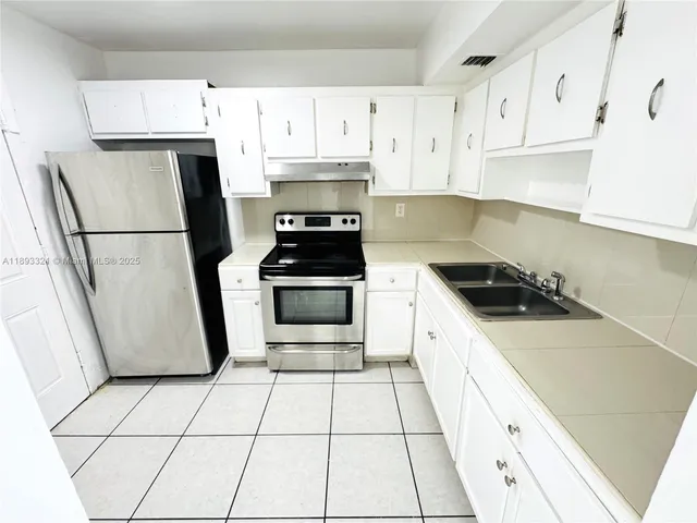 a kitchen with white cabinets a sink and white appliances