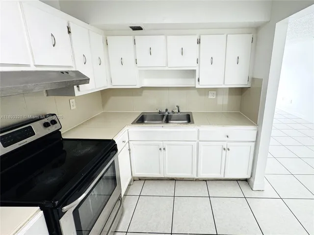 a kitchen with a sink dishwasher and cabinets
