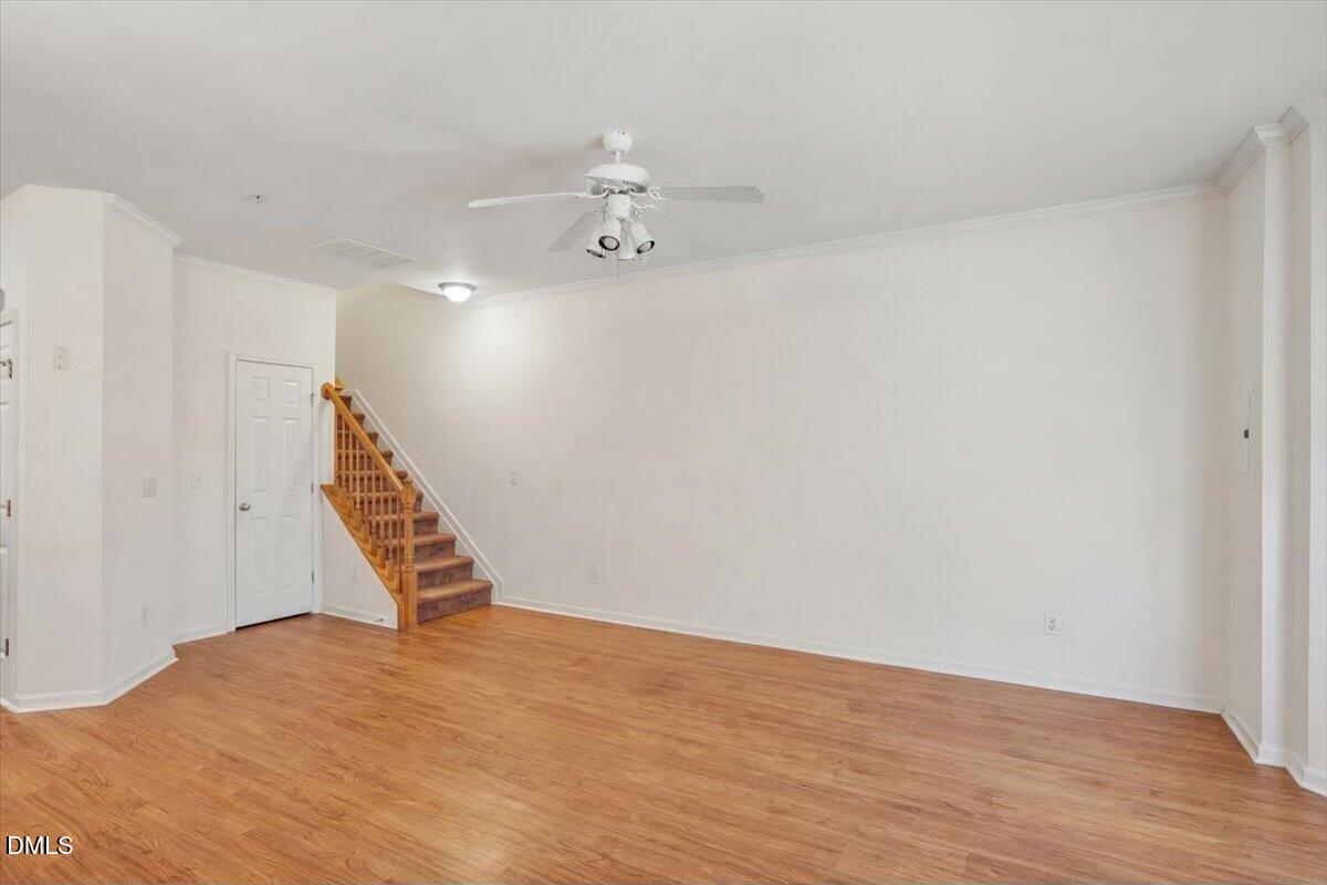2231 Raven Road, Unit 103 Raleigh, NC 27614 - Photo 11 of 26 a view of an empty room with wooden floor and stairs