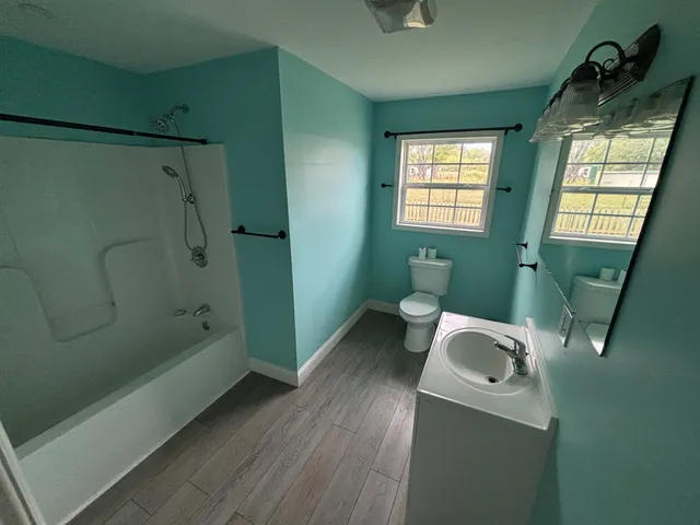 a bathroom with a sink a toilet and shower