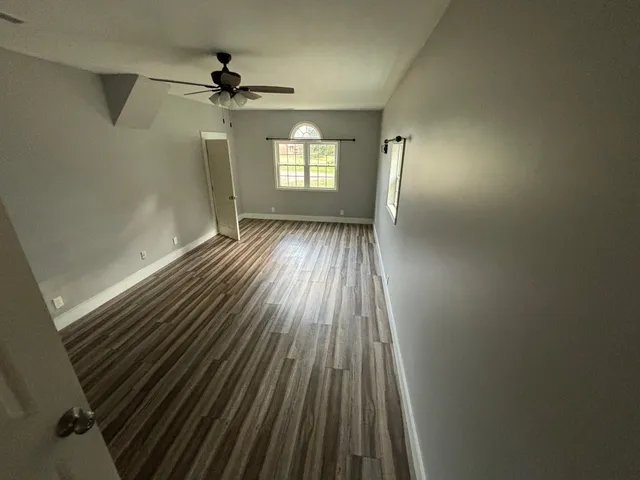 wooden floor in an empty room with a window