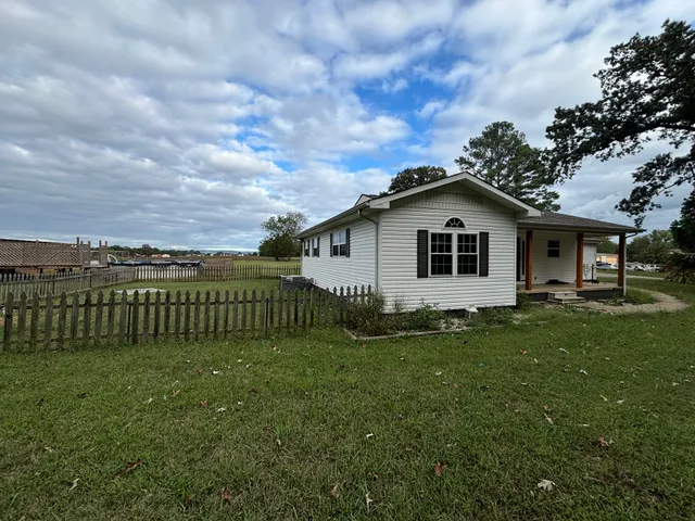 a view of a house with a yard and fence