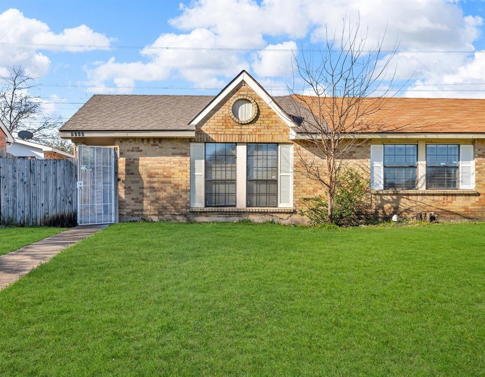 Ranch-style house featuring a front lawn, fence, brick siding, and roof with shingles
