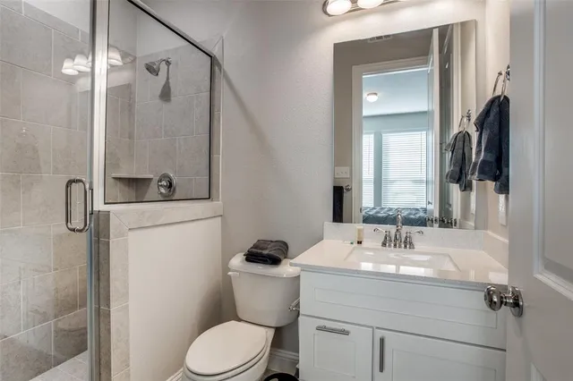 a bathroom with a sink toilet and shower a mirror