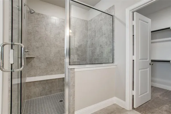 a bathroom with a shower and a glass door