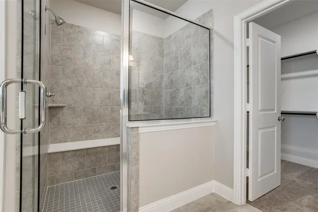 a bathroom with a shower and a glass door