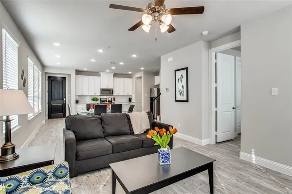 a living room with furniture and a dining table with wooden floor