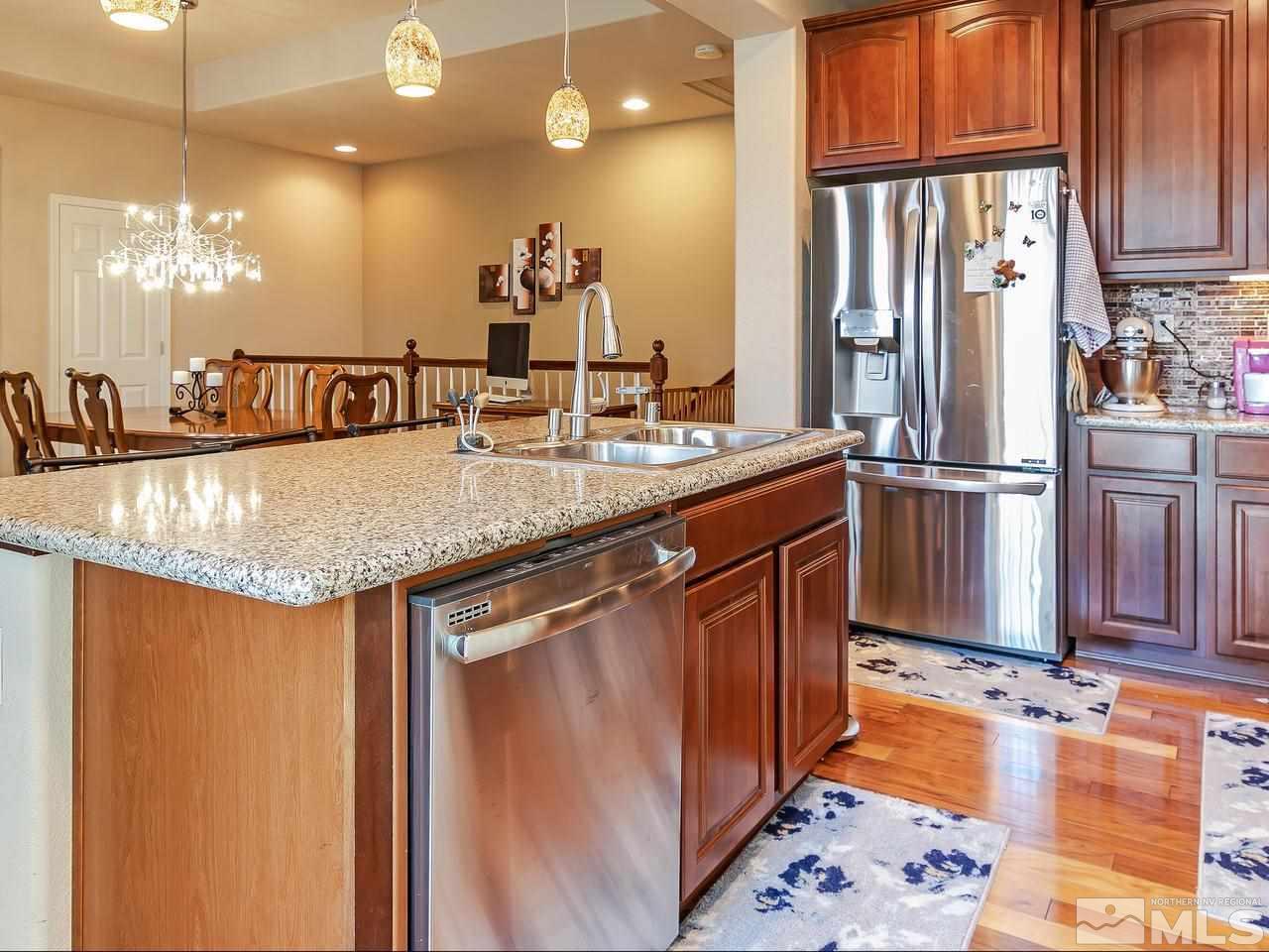 1915 Wind Ranch Road, Unit C Reno, NV 89521 - Photo 8 of 15 a kitchen with stainless steel appliances granite countertop a sink and a refrigerator