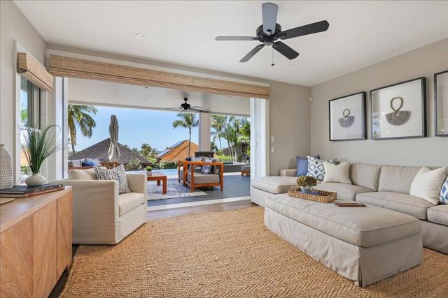 a view of a swimming pool with couches and lounge chairs
