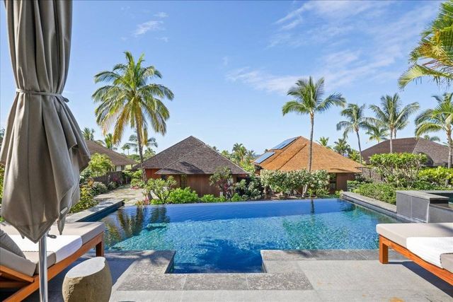 a view of a patio with couches table and chairs potted plants and palm tree
