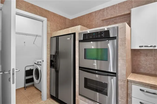 a kitchen with stainless steel appliances granite countertop a refrigerator and a stove