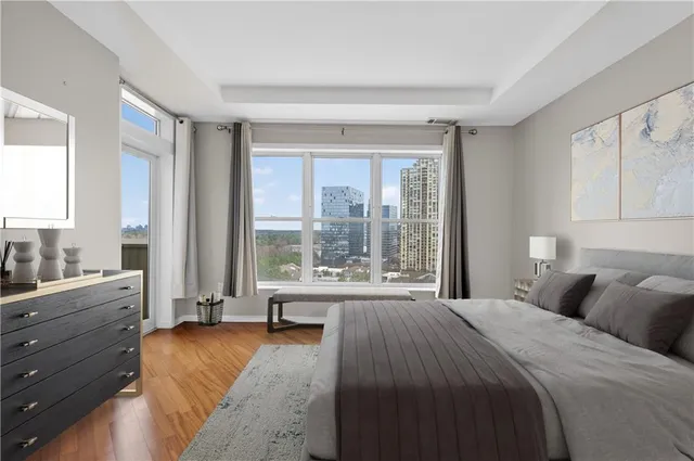 a bedroom with a bed and large windows