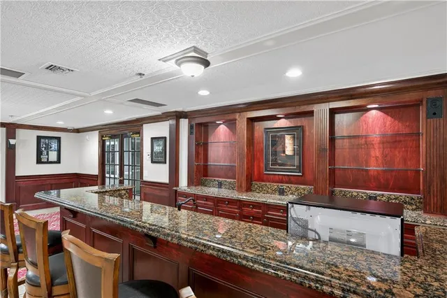 a large kitchen with granite countertop a barbecue grill and large windows