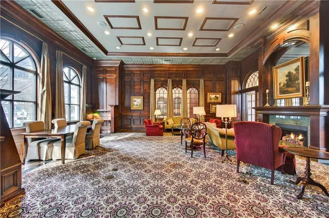 a living room with furniture a fireplace and large windows