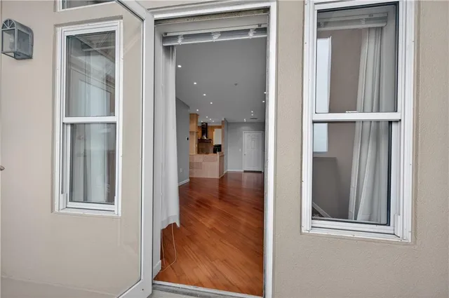 a view of a hallway with wooden floor and entryway
