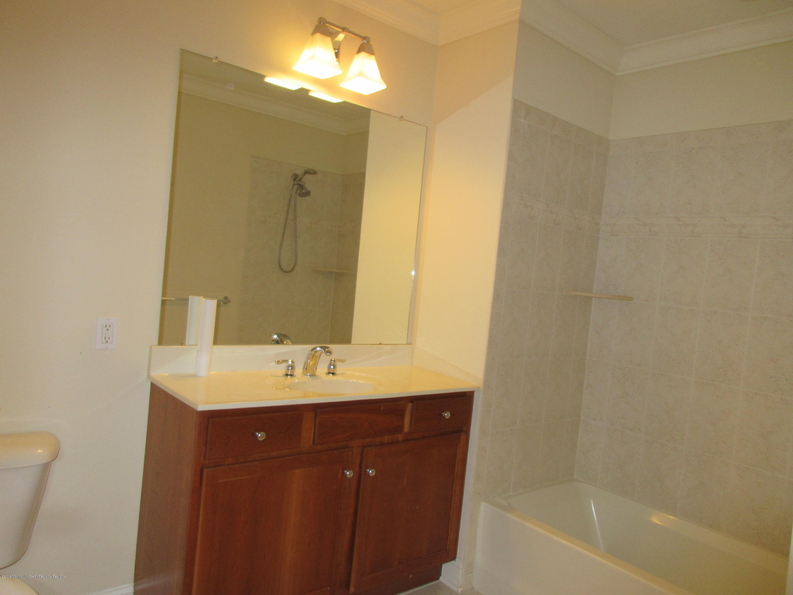 701 Main Street, Unit 301 Belmar, NJ 07719 - Photo 12 of 13 a bathroom with a sink and a mirror