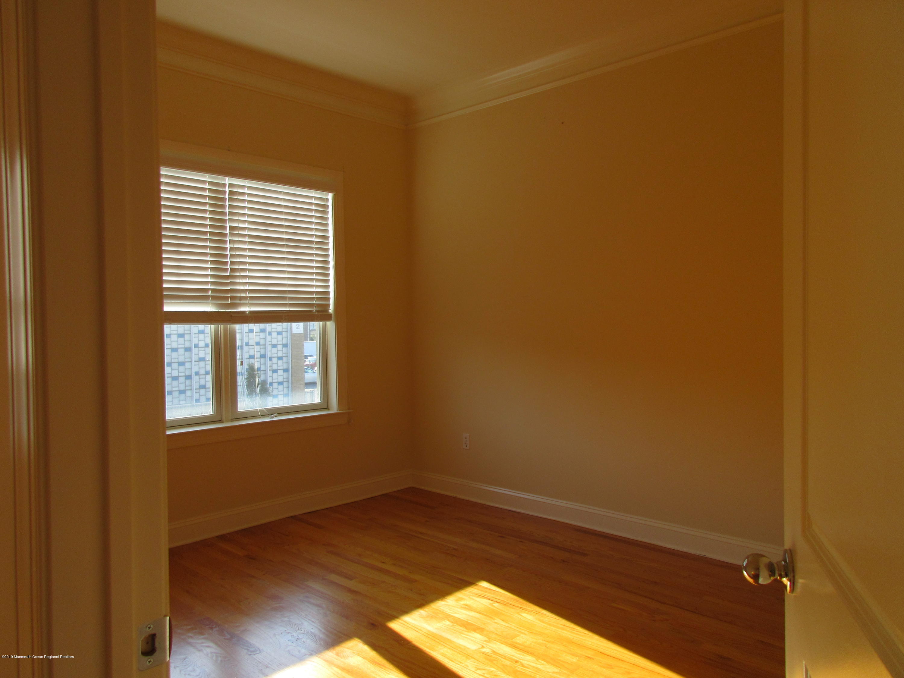 701 Main Street, Unit 301 Belmar, NJ 07719 - Photo 9 of 13 an empty room with wooden floor and windows