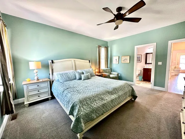 a spacious bedroom with a bed and a chandelier