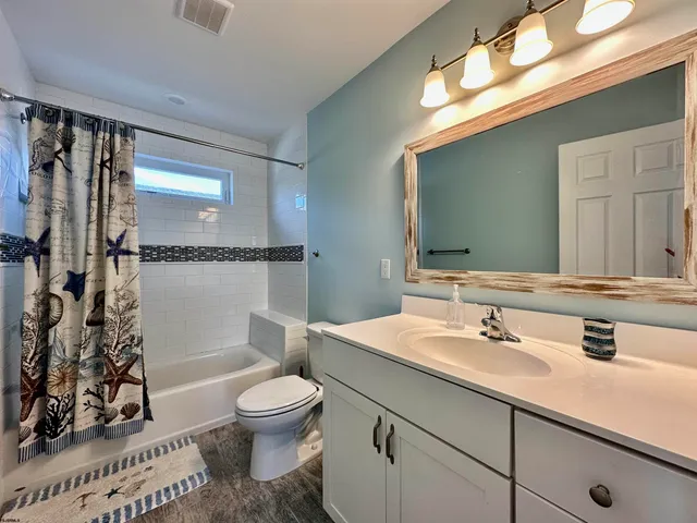 a bathroom with a sink a toilet and mirror