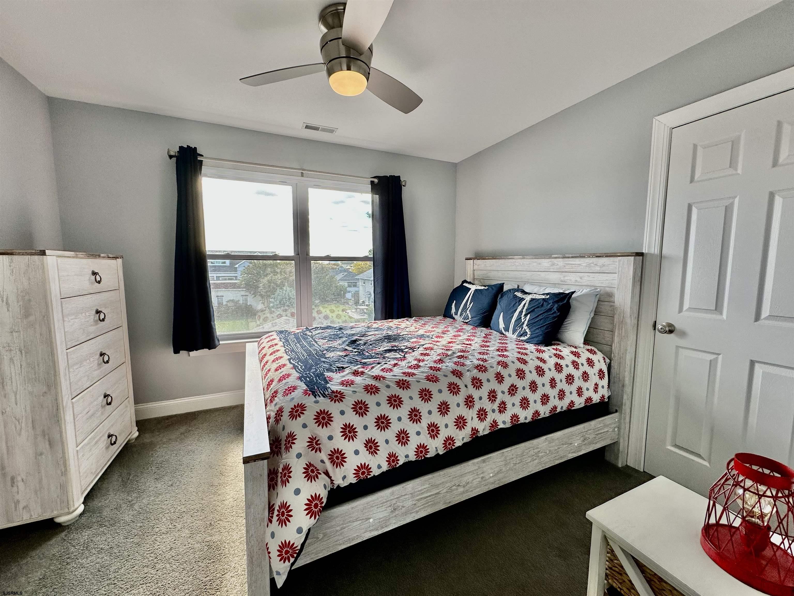 201 19th Street South Brigantine, NJ 08203 - Photo 22 of 29 a bedroom with a large bed and a chandelier
