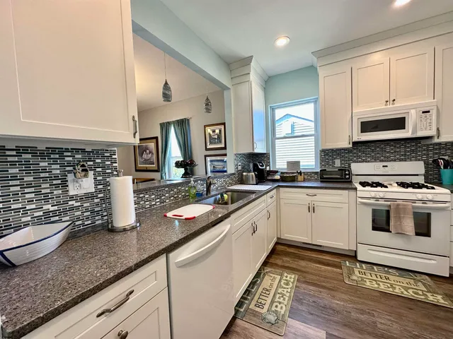 a kitchen with granite countertop a sink a stove and cabinets