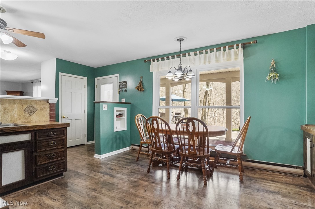 35977 Teegarden Road Salem, OH 44460 - Photo 8 of 50 Dining room featuring dark wood-type flooring, baseboards, and ceiling fan with notable chandelier