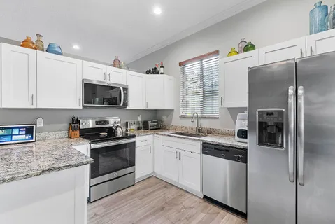 a kitchen with kitchen island granite countertop a sink stainless steel appliances and counter space