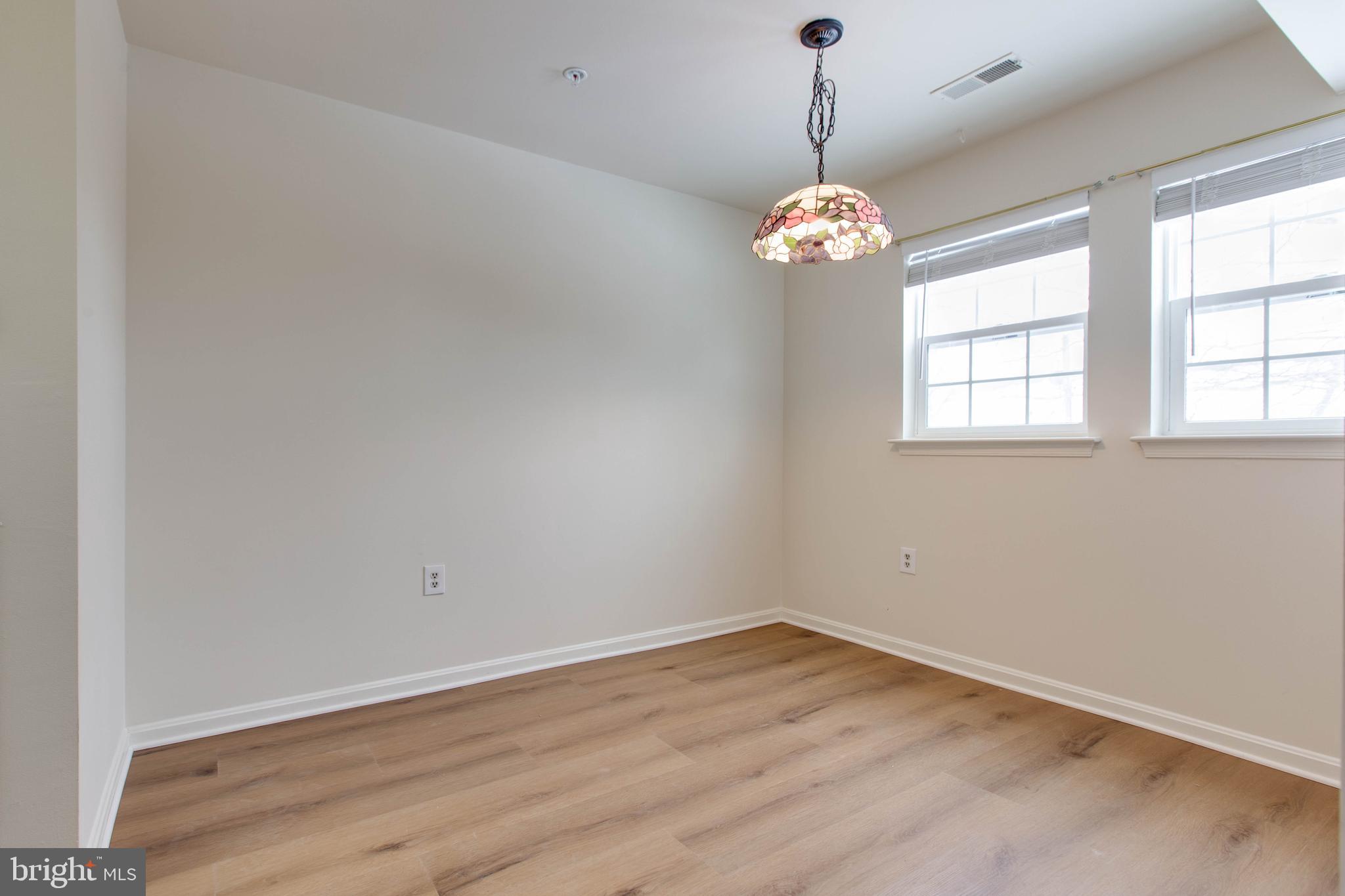 8399 Montgomery Run Road, Unit G Ellicott City, MD 21043 - Photo 13 of 31 an empty room with wooden floor fan and window