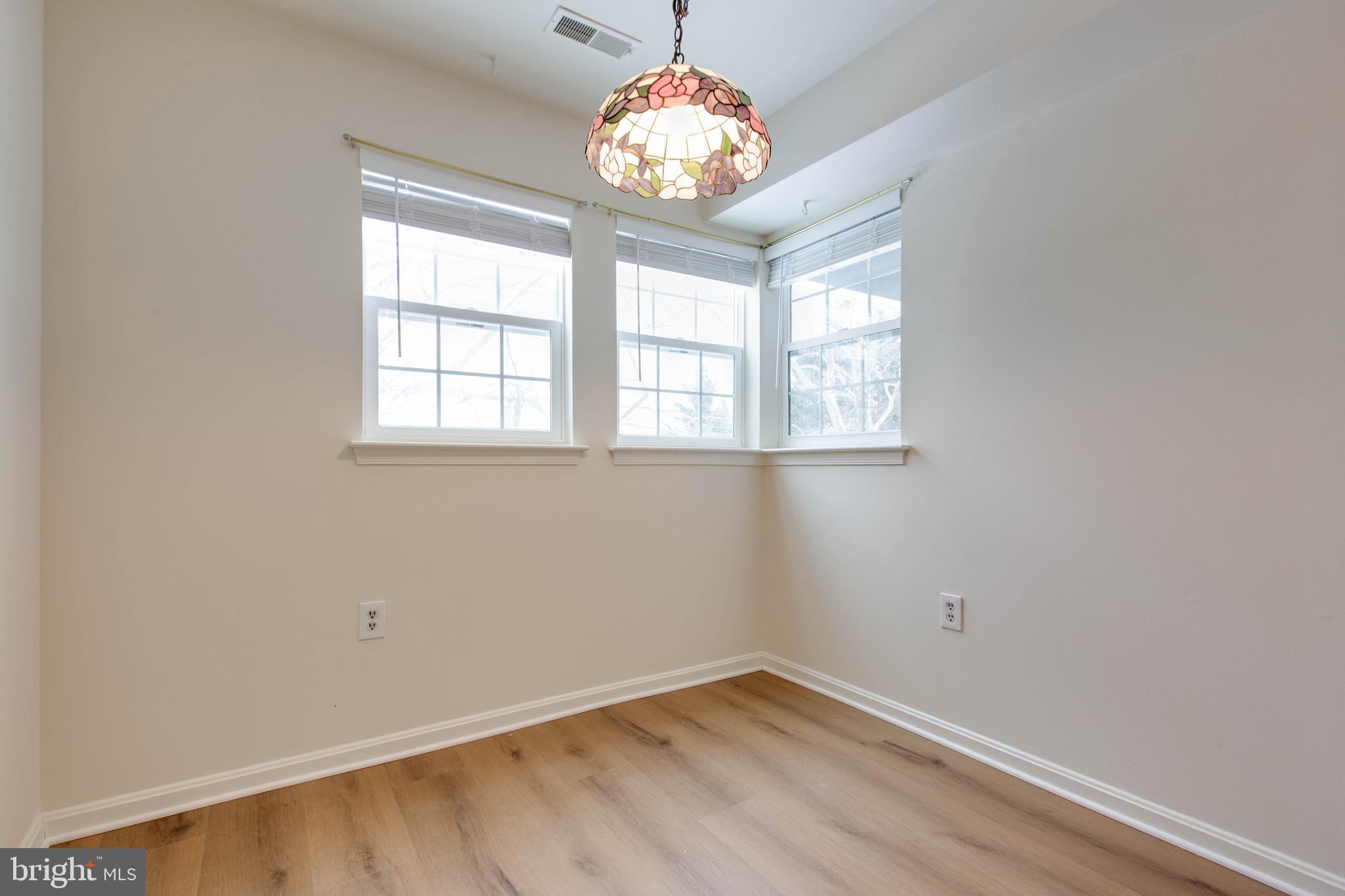 8399 Montgomery Run Road, Unit G Ellicott City, MD 21043 - Photo 15 of 31 an empty room with wooden floor and windows