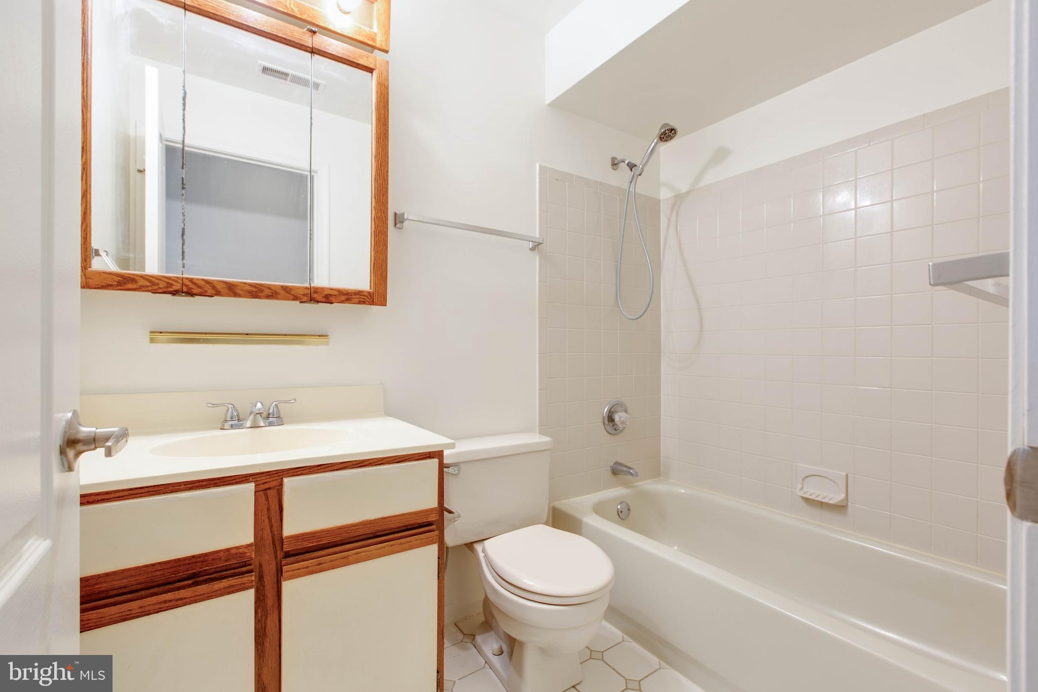 8399 Montgomery Run Road, Unit G Ellicott City, MD 21043 - Photo 25 of 31 a bathroom with a sink toilet and shower