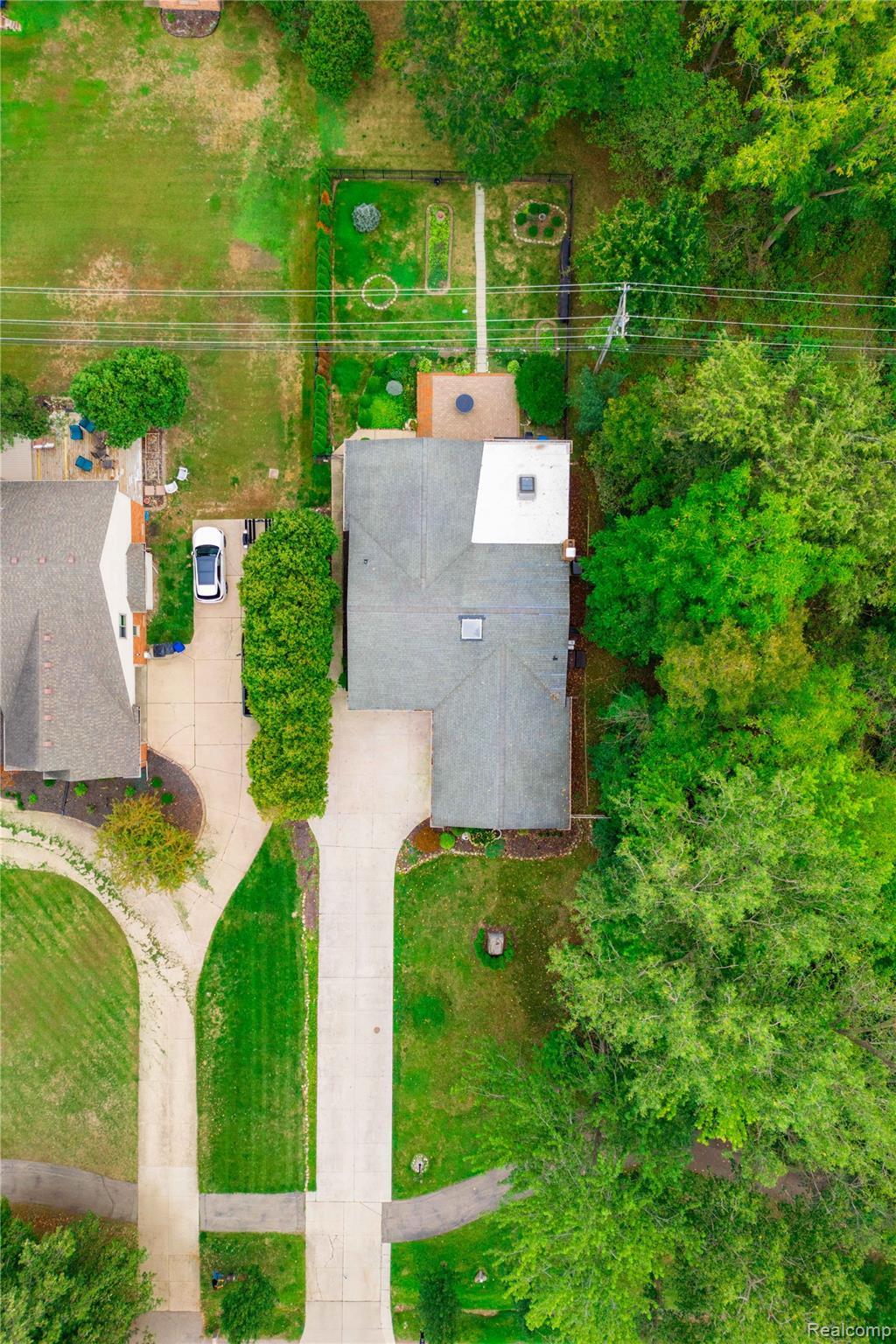 25645 Meridian Road Grosse Ile, MI 48138 - Photo 37 of 46 Extensive paved driveway, mature trees, manicured lawns, and a backyard garden area