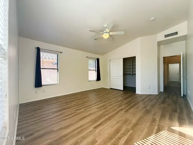 a view of an empty room with window and wooden floor