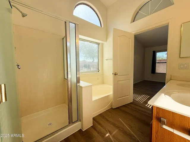a bathroom with a glass door shower and a sink