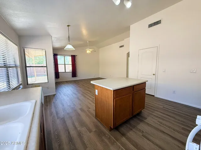a kitchen with wooden floors and windows