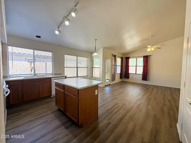 a kitchen with stainless steel appliances granite countertop a sink a counter space and wooden floor