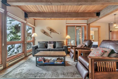 a living room with furniture a flat screen tv and a large window