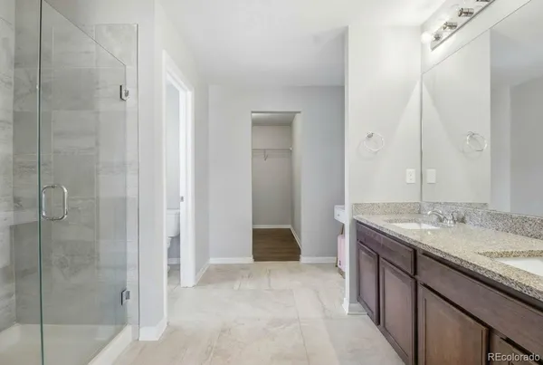 a bathroom with a granite countertop sink a mirror and a shower