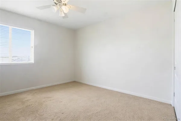 an empty room with a chandelier fan