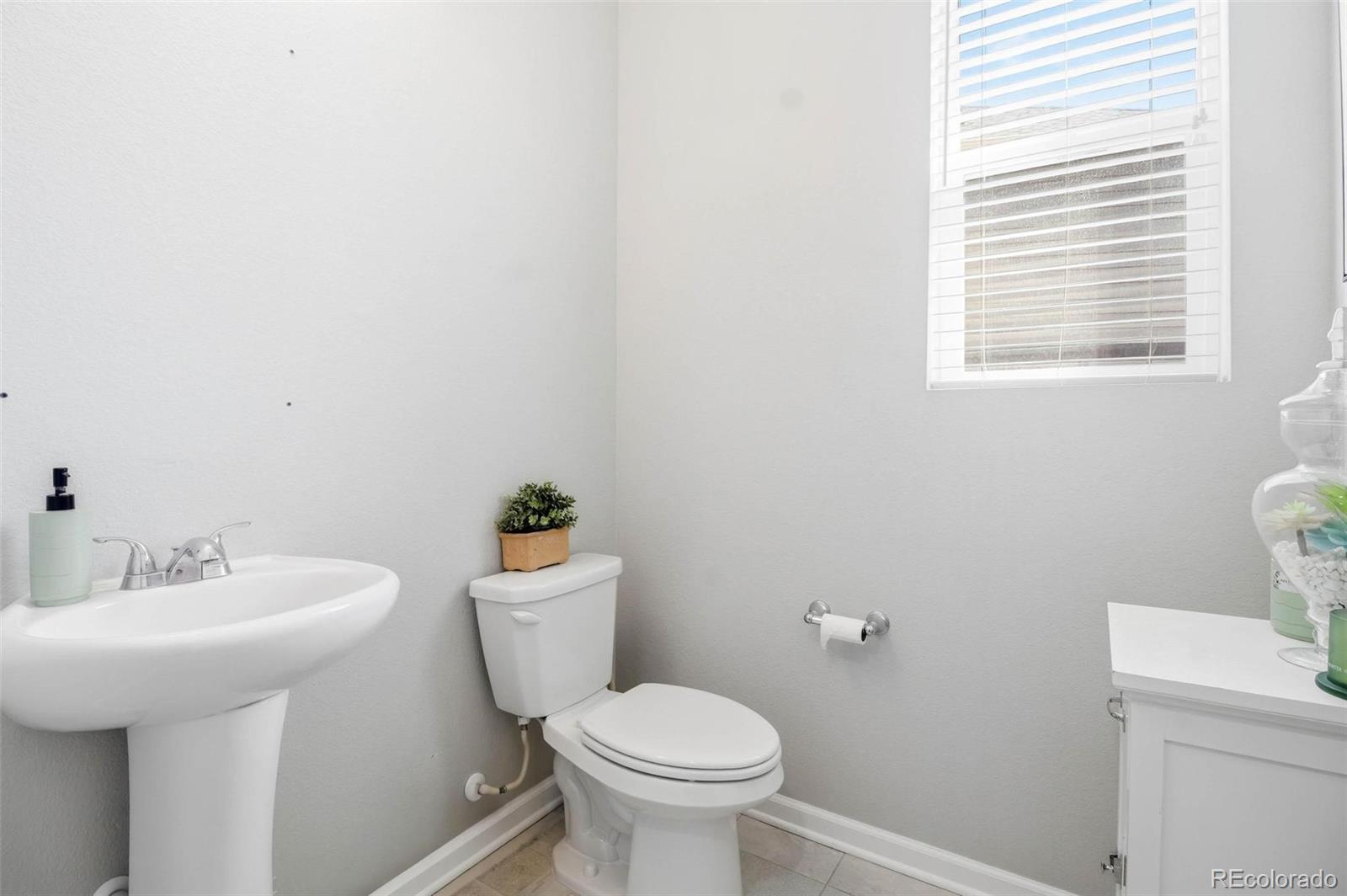 16343 East 100th Way Commerce City, CO 80022 - Photo 19 of 31 a bathroom with a toilet sink and mirror