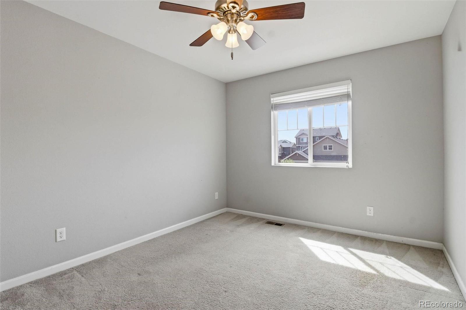 16343 East 100th Way Commerce City, CO 80022 - Photo 20 of 31 an empty room with chandelier fan and windows