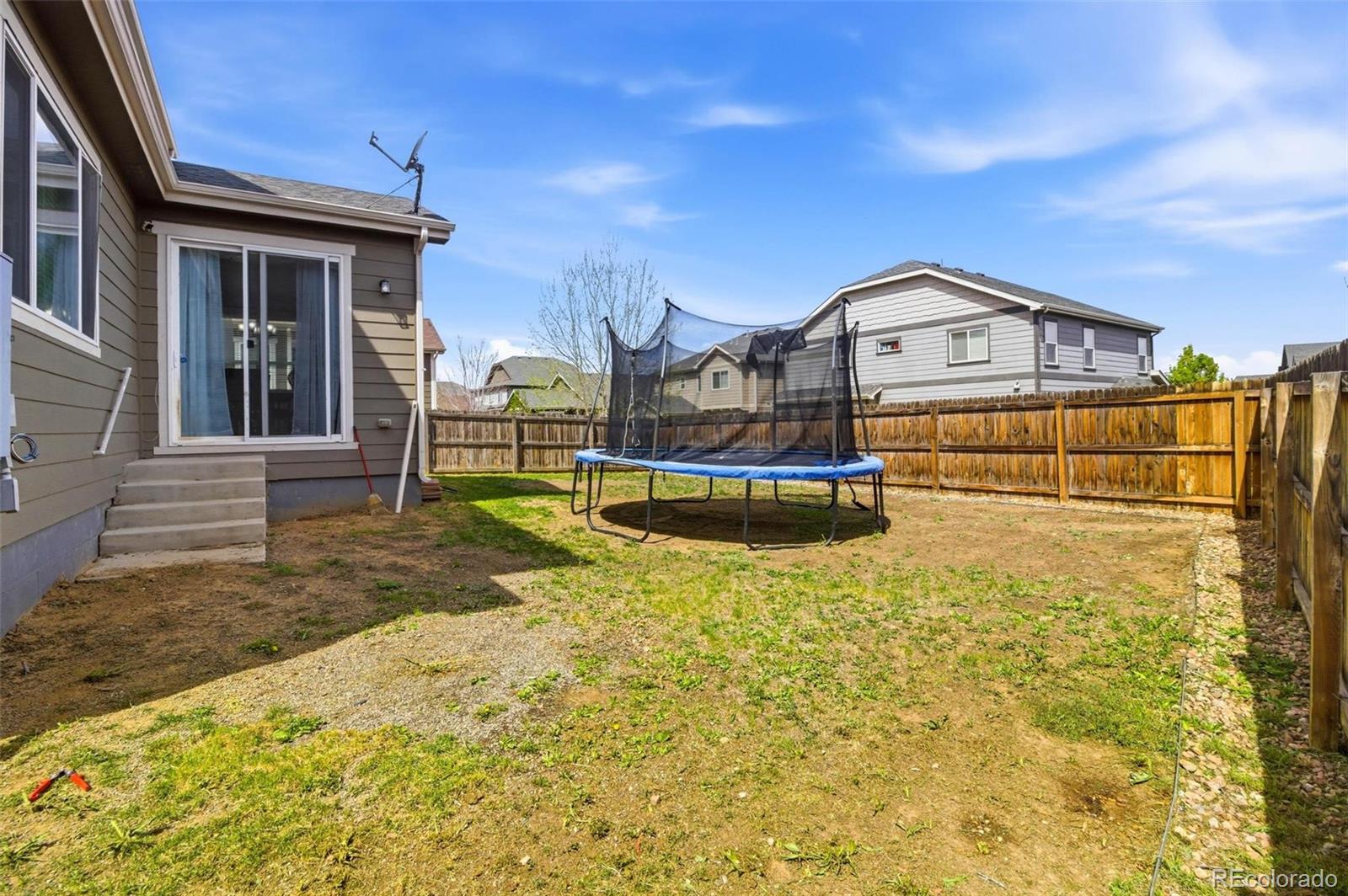 16343 East 100th Way Commerce City, CO 80022 - Photo 30 of 31 a view of a house with a large tree and wooden fence