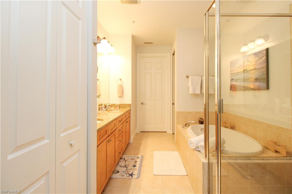 9159 Delano Street, Unit 9905 Naples, FL 34113 - Photo 32 of 44 Bathroom featuring vanity, independent shower and bath, and tile patterned flooring