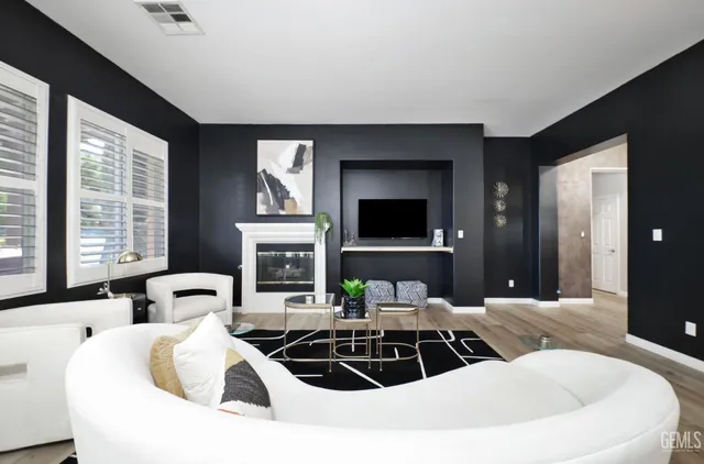 a living room with furniture a large window and a flat screen tv