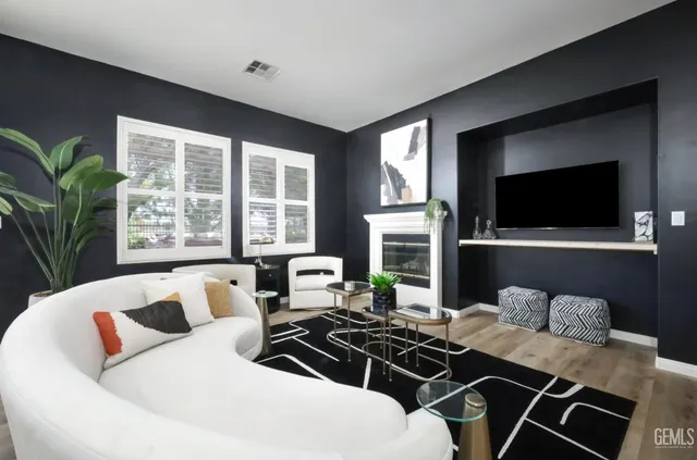 a living room with furniture a flat screen tv and a large window