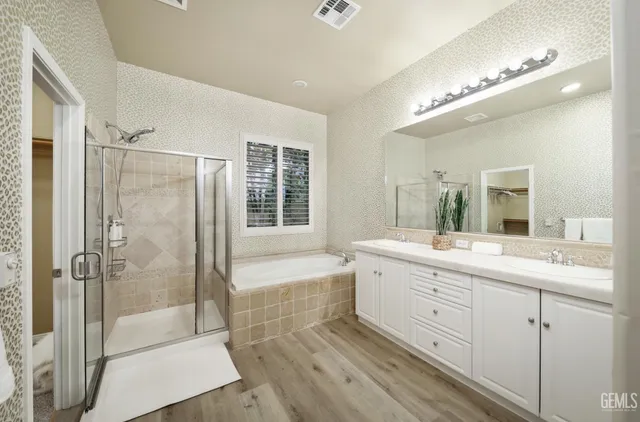 a bathroom with a double vanity sink a large mirror and shower