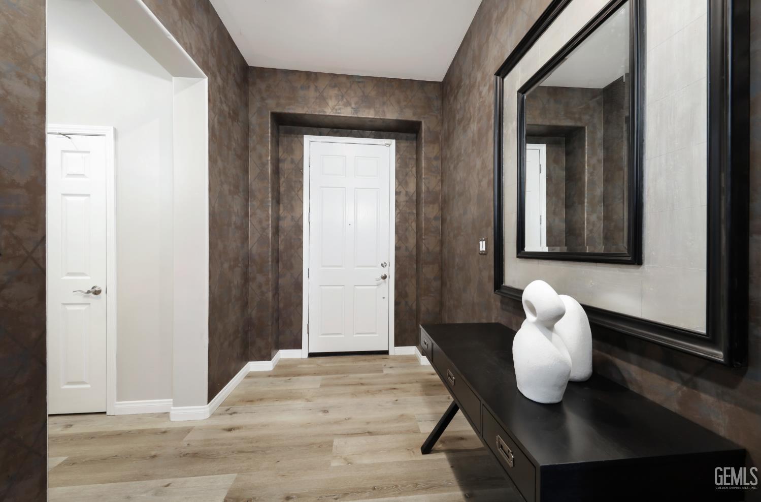 Undisclosed Address Bakersfield, CA 93312 - Photo 27 of 44 a view of a hallway with dining room and wooden floor