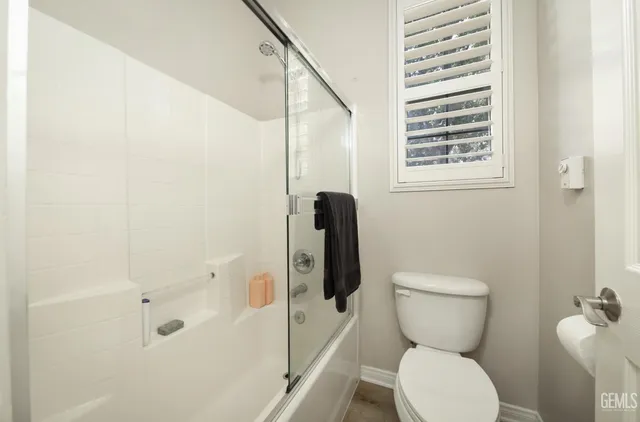 a spacious bedroom with a bed and a lamp